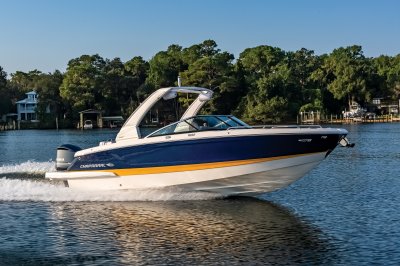 Chaparral 270 OSX cruising on a lake with a treeline in the background. 