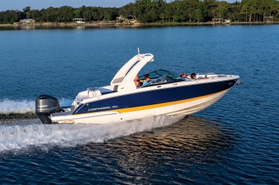 Chaparral 270 OSX gaining speed near the shoreline with docks and houses in the background. 